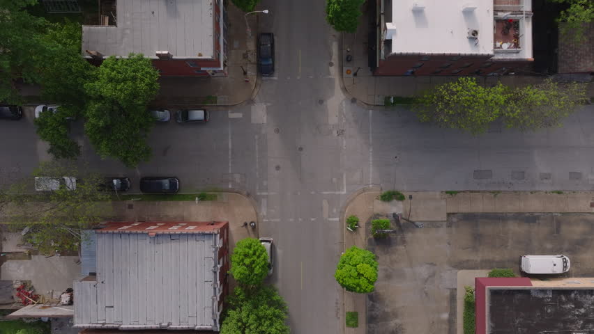 Calm streets and homes of a vibrant American city neighborhood from a special aerial view. Greenery and urban architecture from above