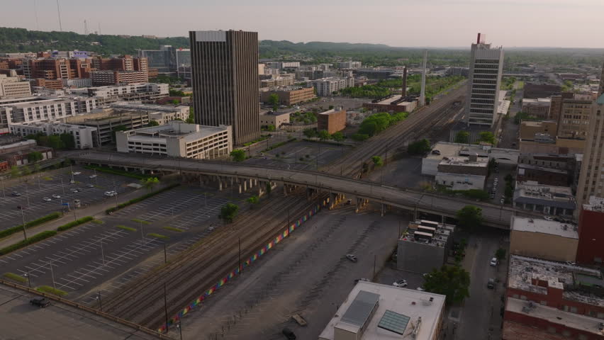 Aerial view of Birmingham, USA, railway system at dusk. Tall buildings, highway traffic, and urban landscape. Serene evening ambiance in the cityscape