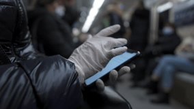 Mature woman use gadget in subway wear protective medical mask and gloves during coronavirus. Elderly female surfing Internet in smartphone in public transport, covid 19, keep your distance, new norm. - Powered by Shutterstock - Get 15% off with code: PIKWIZARD15