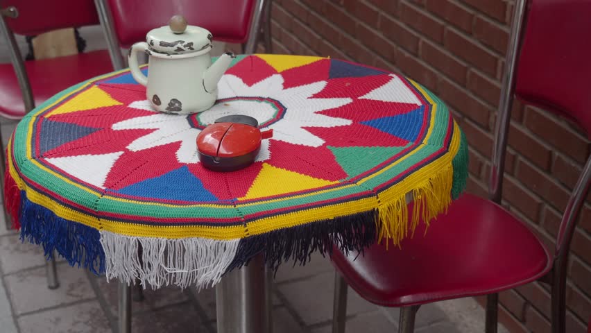 Outdoor cafe table with tea and decorations creates cozy dining experience in vibrant patio