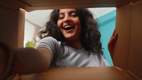 View from inside the box. Happy Indian woman unpacking delivery parcel at home. Smiling satisfied girl shopper, online shop customer opens cardboard box receiving purchase gift by fast postal shipping - Powered by Shutterstock - Get 15% off with code: PIKWIZARD15