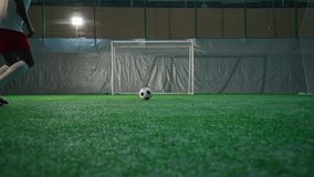 Black soccer player exercising penalty in training hall, scoring goal, back view - Powered by Shutterstock - Get 15% off with code: PIKWIZARD15