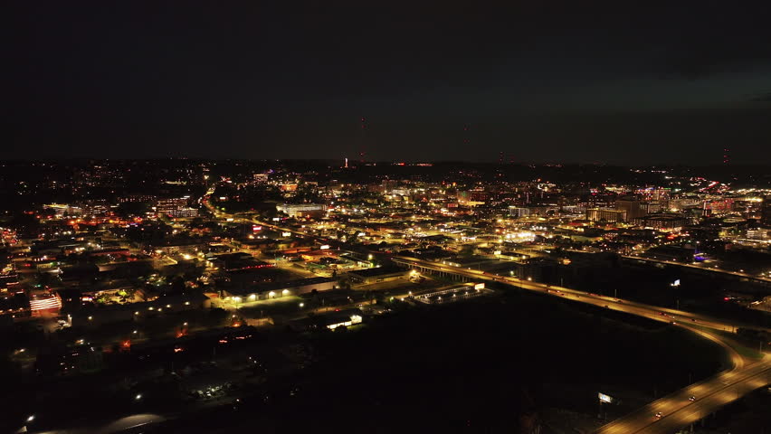 Stunning night view of an American city from a high vantage point. Bright city lights, bustling highways, and downtown area