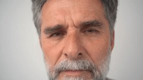 Close-up portrait of a mature man. Brown eyes of a senior guy close-up, natural beauty. The  guy looks at the camera, blinks, and smiles. Full-face view.  - Powered by Shutterstock - Get 15% off with code: PIKWIZARD15