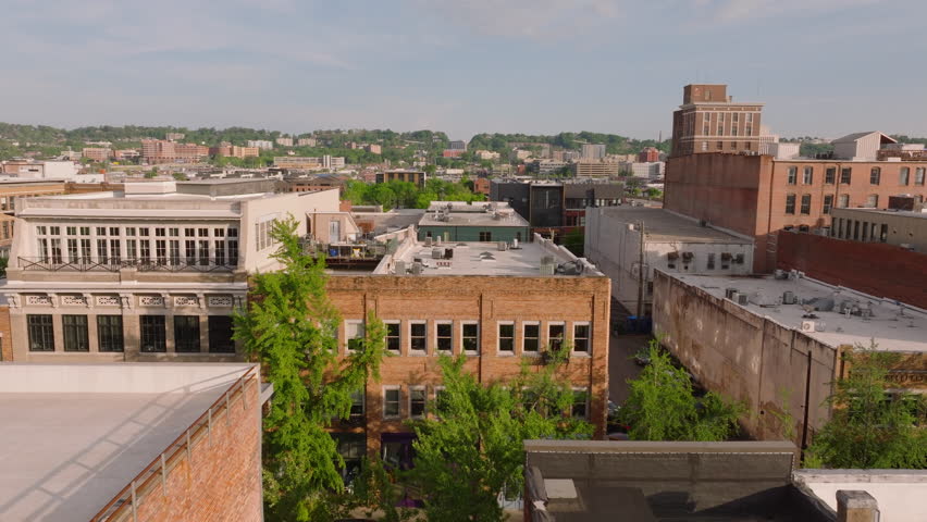 Medium-sized American city residential buildings rooftops and industrial buildings from above on a clear day. City