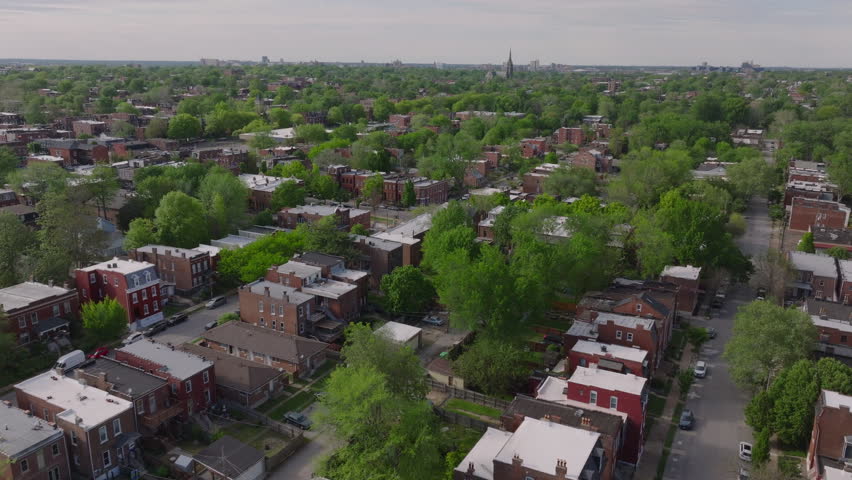 Aerial view of a vibrant St. Louis neighborhood in full spring bloom, featuring homes and treelined streets outside town