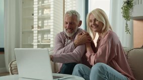 Happy senior family Caucasian couple elderly woman man talking online video call female male using laptop computer pc mature husband wife laugh cuddle hug talk internet virtual chat indoor living room - Powered by Shutterstock - Get 15% off with code: PIKWIZARD15