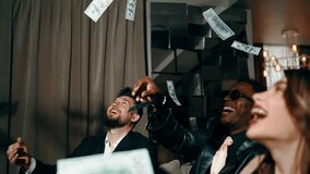 A group of young people in stylish suits throw dollar bills up. Lottery and casino concept. Friends throw money up. 4k - Powered by Shutterstock - Get 15% off with code: PIKWIZARD15