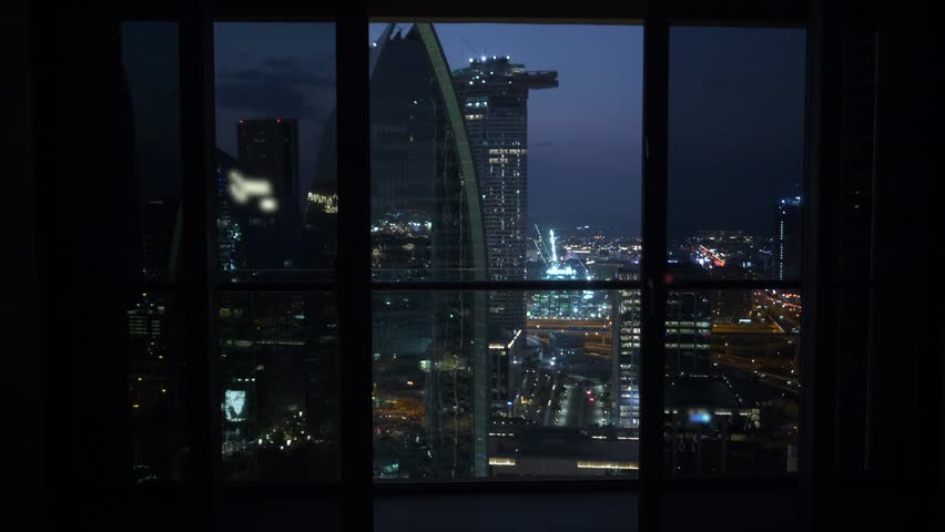 Man Stands Near the Window of the Building to See a Panoramic View of Urban 