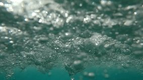 Rain drops and air bubbles during heavy tropical downpour, drops fall onto water surface and foam it, slow motion, closeup. Underwater view of power rainfall. Heavy waterdrops of rainstorm below water - Powered by Shutterstock - Get 15% off with code: PIKWIZARD15