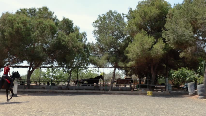 Professional female jockey rides on horseback. Horse runs on the sand . Slow motion video