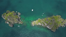 Beautiful uninhabited islands in the south of Thailand, tourists snorkeling from a yacht while traveling, 4k drone video