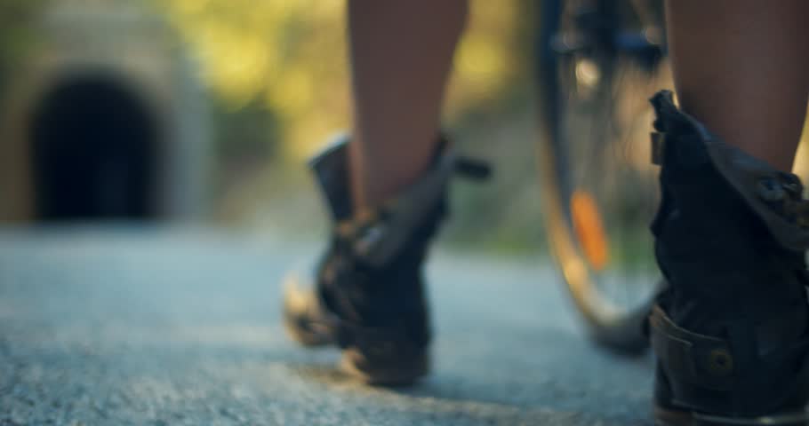 Woman Walking with her Bike go into Dark Tunnel with Military Checkpoint	
