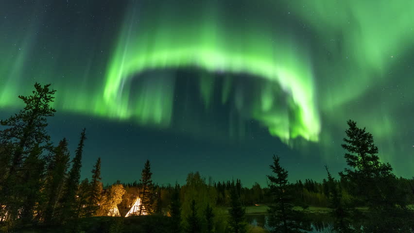 Amazing northern lights dancing over the light up Tipi or Tepees at Aurora Village in Yellowknife, Northwest Territories, Canada.