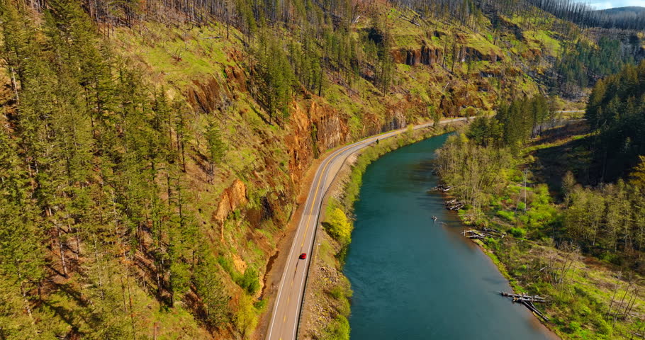 Bare rocks and narrow river at the foot. Sunny view of the mountains in Oregon State, the USA.