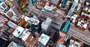 Drone footage over the tops of high-rise buildings in the center of Seattle, Washington, the USA. Heavy traffic by the highways in the downtown. Top view.