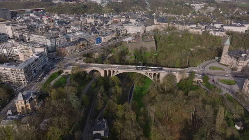 Stunning aerial view of Luxembourg City, showcasing its historic bridge Pont Adolphe, green parks, and magnificent architecture