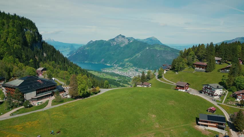 Picturesque view of lake Lucerne and green mountains in Switzerland. Valley with small houses surrounded by hills and lake with turquoise water in Stoos, Swiss
