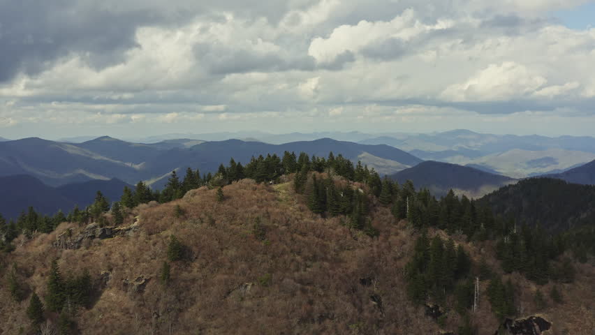 Drone passing over peak in Blue Ridge Mountains to reveal scenic valley below