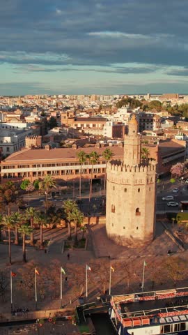 Seville old town with Torre del Oro tower, Cathedral and other historic buildings at sunset, Andalusia region, Spain. Aerial drone footage of Seville cityscape in spring