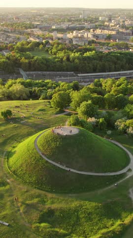 Aerial summer view of the Krakus Mound with beautiful sunset view of the historical part of Krakow old town, Poland. Popular place to watch sunset in Cracow. Drone footage. Summer in Krakow