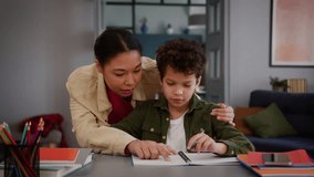 African American family little boy child kid son pupil studying home education writing homework task learning study mother woman female mom come in room walk go embrace cuddle schoolboy help with math - Powered by Shutterstock - Get 15% off with code: PIKWIZARD15