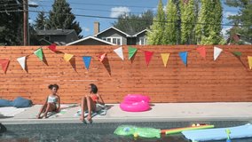 Sisters setting up beach towels for sunbathing at sunny summer poolside - Powered by Shutterstock - Get 15% off with code: PIKWIZARD15