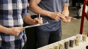 Male brewers examining hops in brewery - Powered by Shutterstock - Get 15% off with code: PIKWIZARD15