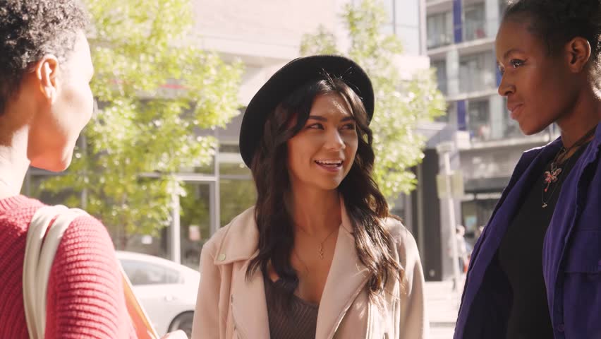 Confident smiling young women friends talking in sunny city