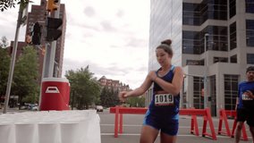 Female marathon runners running and grabbing water at water table on urban street - Powered by Shutterstock - Get 15% off with code: PIKWIZARD15