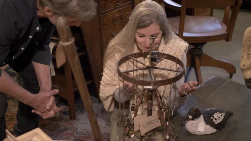 Couple looking at vintage necklaces in antique shop