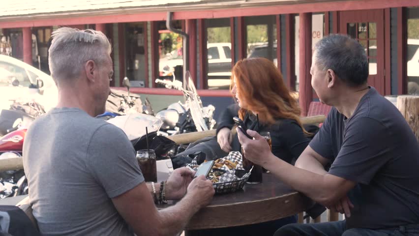 Motorcyclists drinking and eating outside bar