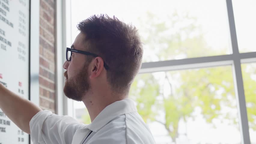 Man altering price list on board in shop