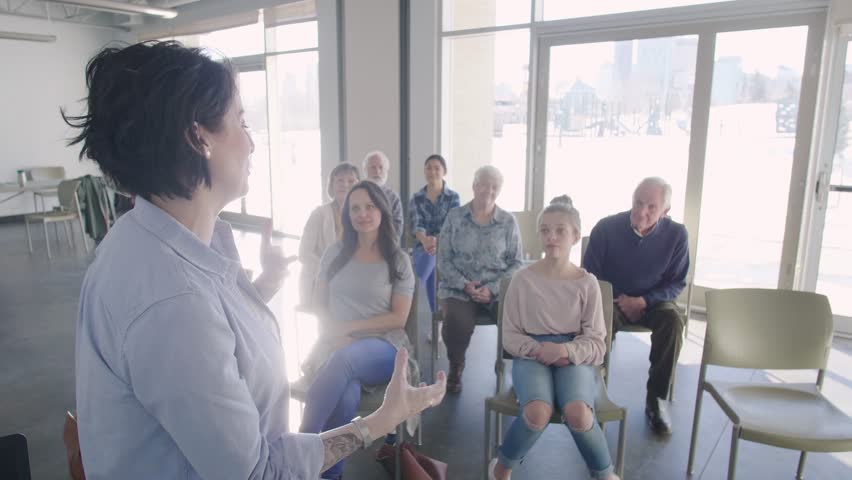 Female speaker giving presentation to audience in community center