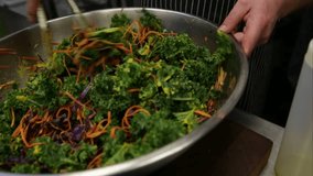 Chef tossing kale salad with tongs commercial kitchen - Powered by Shutterstock - Get 15% off with code: PIKWIZARD15