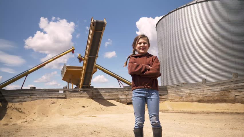 Portrait confident girl below silo on sunny rural farm