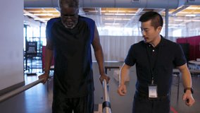 Physical therapist helping senior patient walking at parallel bars - Powered by Shutterstock - Get 15% off with code: PIKWIZARD15