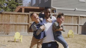 Cheerful family playing and hugging on backyard lawn - Powered by Shutterstock - Get 15% off with code: PIKWIZARD15