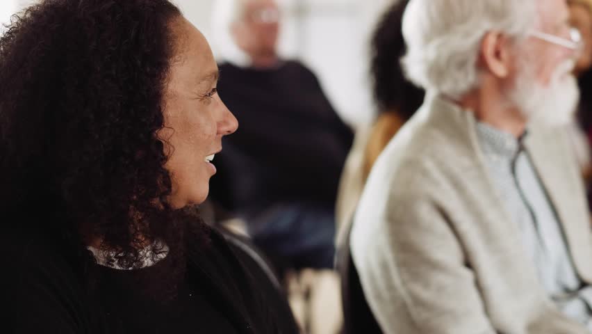 Audience sitting and listening in town hall meeting in community center