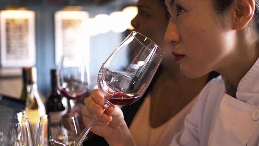 Close up female chef and manager wine tasting in restaurant