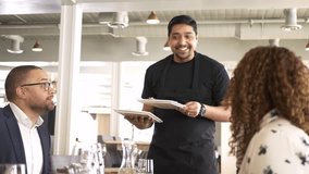 Friendly waiter serving food to couple dining in restaurant - Powered by Shutterstock - Get 15% off with code: PIKWIZARD15