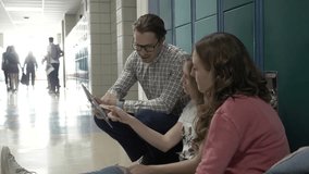 High school teacher with digital tablet talking to students at lockers - Powered by Shutterstock - Get 15% off with code: PIKWIZARD15