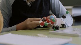 Junior high students assembling molecule model in classroom - Powered by Shutterstock - Get 15% off with code: PIKWIZARD15