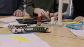 Male junior high science teacher helping boy students assembling wind turbine in classroom - Powered by Shutterstock - Get 15% off with code: PIKWIZARD15