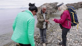 Active senior women friends looking at rocks on rugged ocean beach - Powered by Shutterstock - Get 15% off with code: PIKWIZARD15