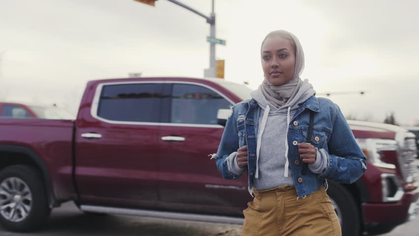Portrait confident young woman in headscarf on urban street corner