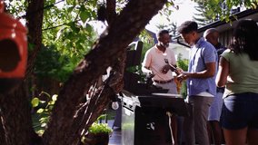 Multigenerational family barbecuing at barbecue grill on summer patio - Powered by Shutterstock - Get 15% off with code: PIKWIZARD15