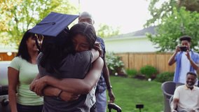 Teenage girl hugging high school graduate sister on patio - Powered by Shutterstock - Get 15% off with code: PIKWIZARD15