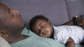 Serene baby son sleeping on fathers chest on sofa - Powered by Shutterstock - Get 15% off with code: PIKWIZARD15