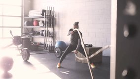 Senior man using battle ropes in sunny cross training gym - Powered by Shutterstock - Get 15% off with code: PIKWIZARD15